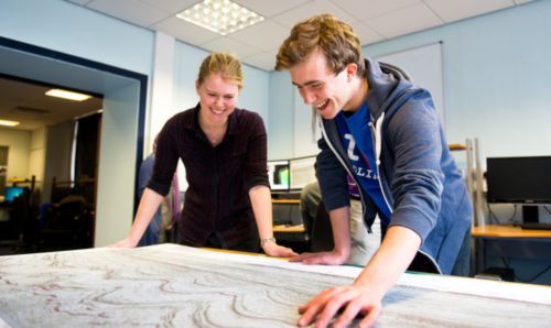 Two researchers working together looking at something on a desk in front of them